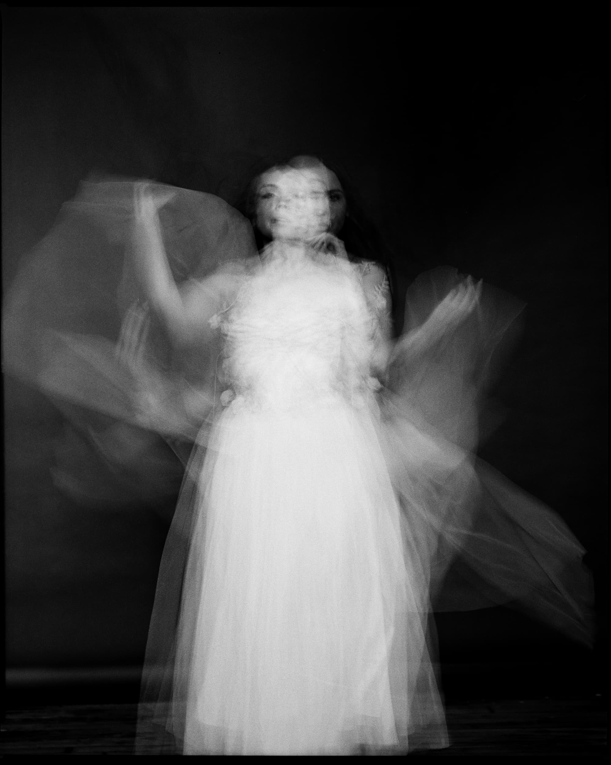 Film photograph — long exposure figure in motion, seeing through time. Kodak Tri-X 400.